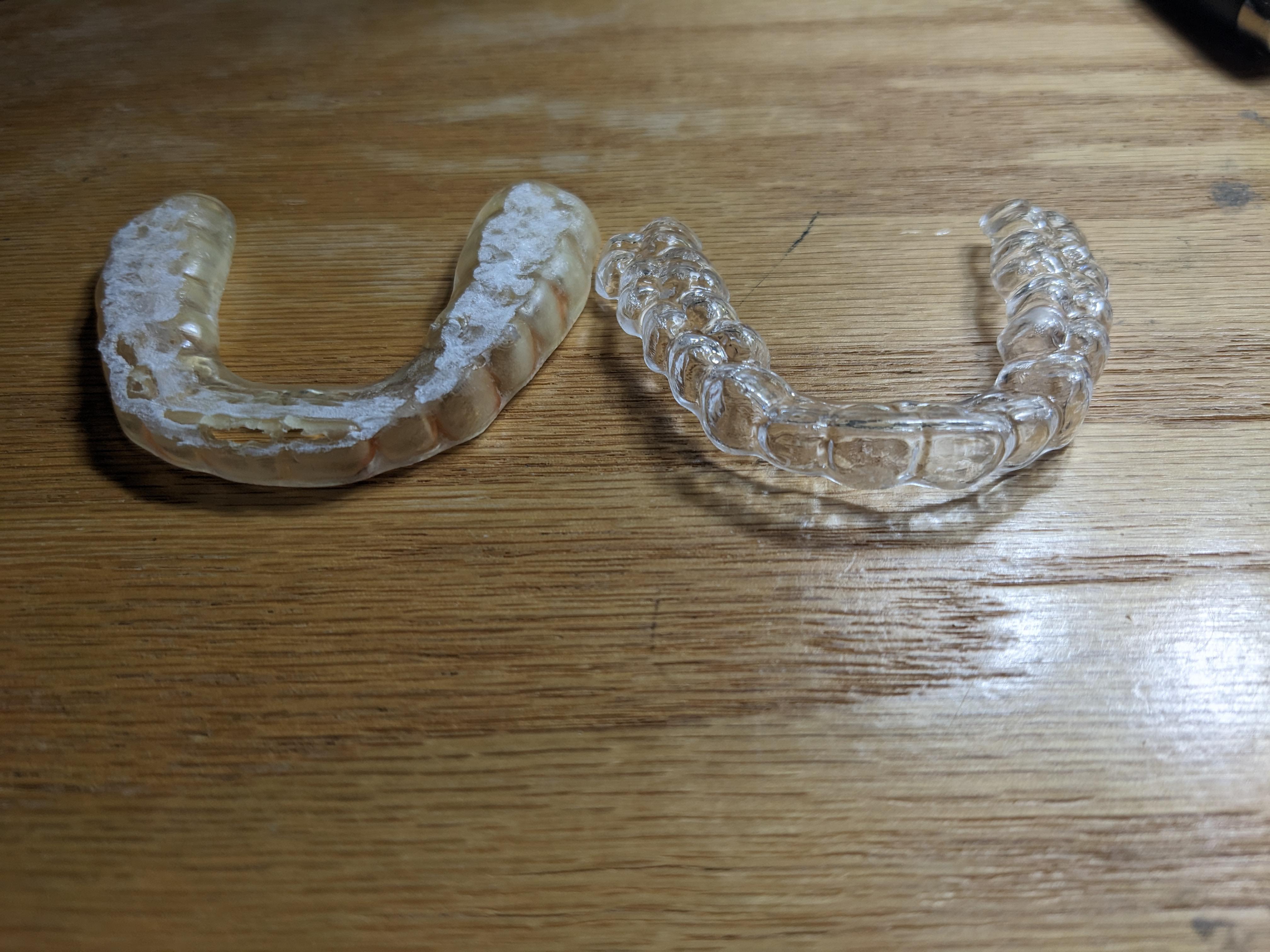 Two clean aligners on a wooden table